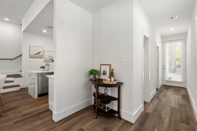 a view of a hallway with wooden floor and furniture