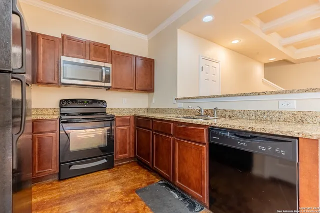 a kitchen with granite countertop a sink stove and microwave