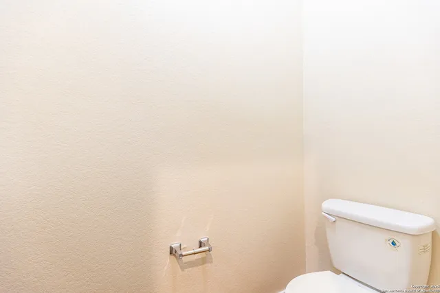 a white toilet sitting next to a white wall