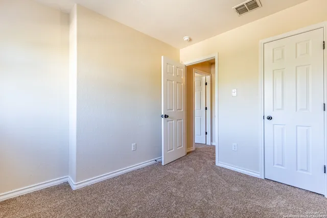 an empty room with closet and mirror