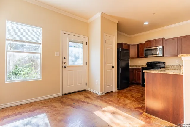 a kitchen with stainless steel appliances granite countertop a refrigerator and a stove top oven