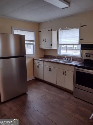 a kitchen with granite countertop a refrigerator and a sink