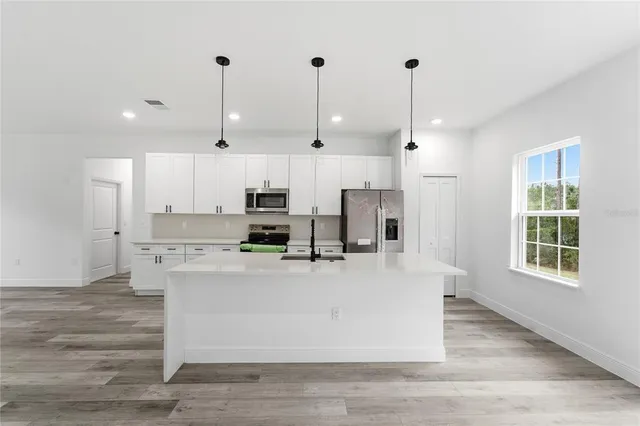 a kitchen with stainless steel appliances a refrigerator sink and microwave