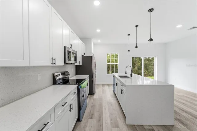 a kitchen with stainless steel appliances a refrigerator sink and microwave