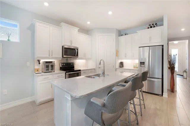 a kitchen with granite countertop a sink a stove and microwave
