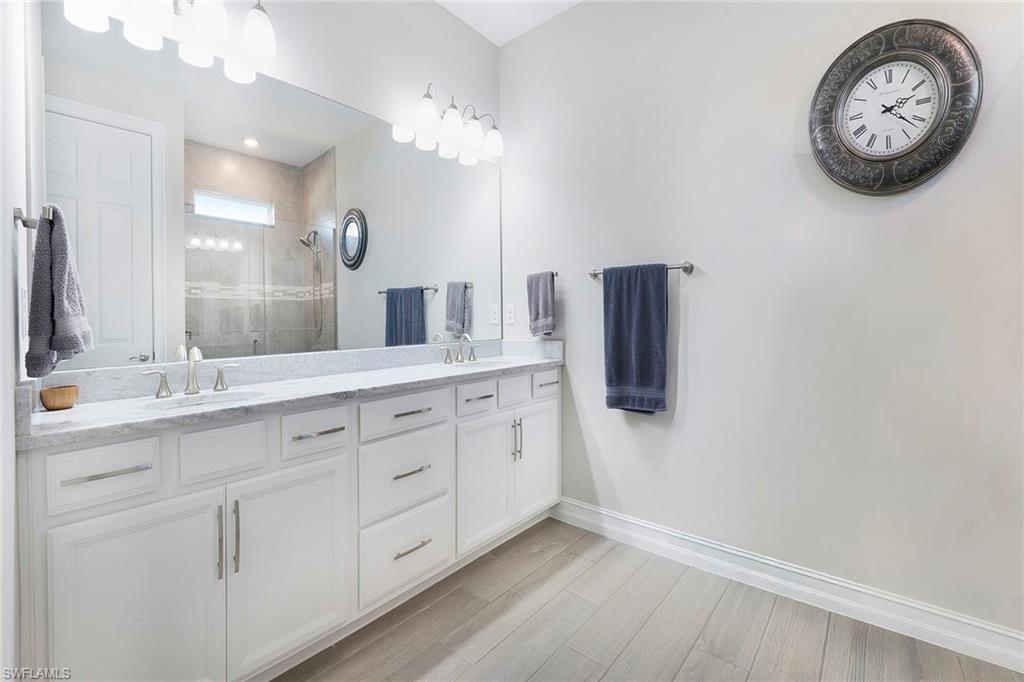 14534 Kelson Circle Naples, FL 34114 - Photo 18 of 50 a spacious bathroom with a double vanity sink and a mirror