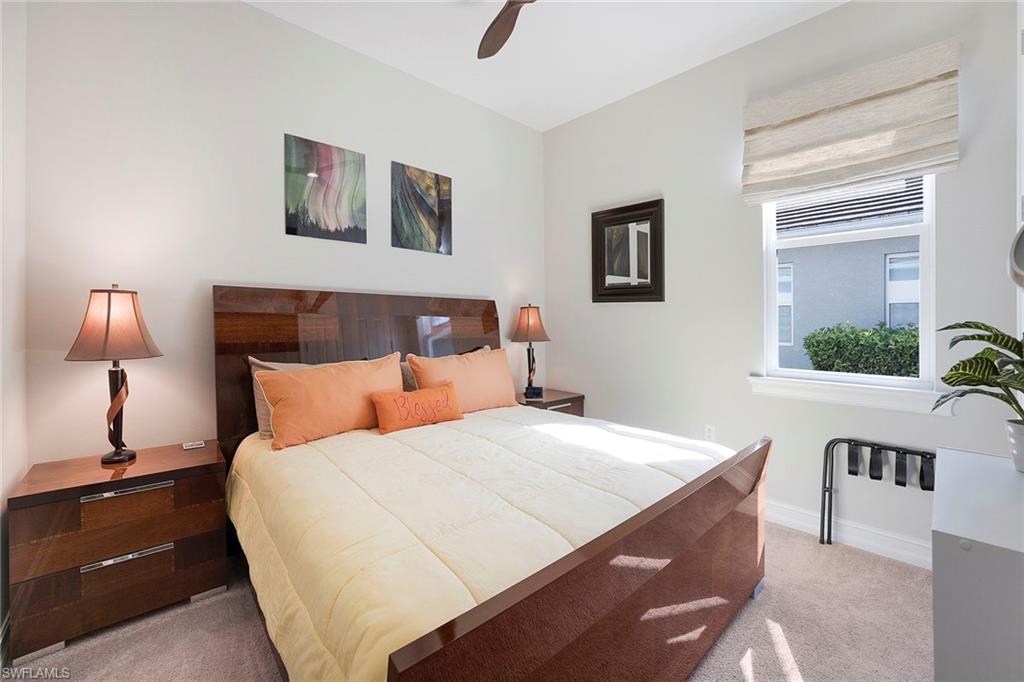 14534 Kelson Circle Naples, FL 34114 - Photo 21 of 50 a bedroom with a large bed and a lamp on table