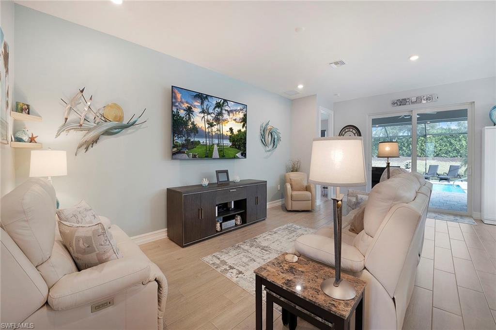 14534 Kelson Circle Naples, FL 34114 - Photo 6 of 50 a living room with furniture a flat screen tv and a fireplace