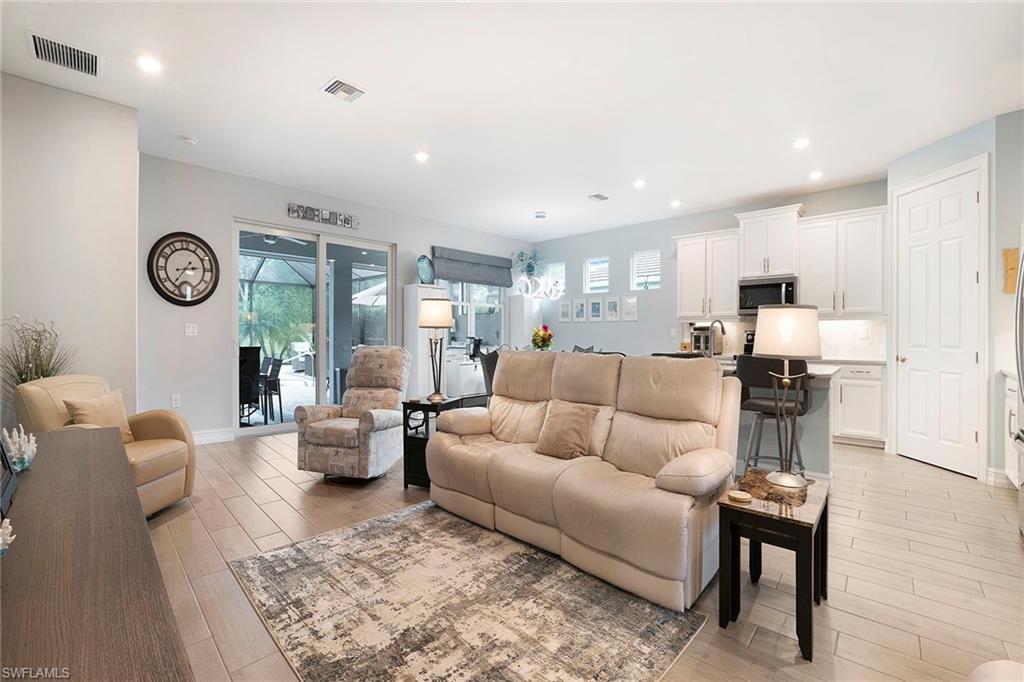14534 Kelson Circle Naples, FL 34114 - Photo 7 of 50 a living room with furniture a clock on wall and a window