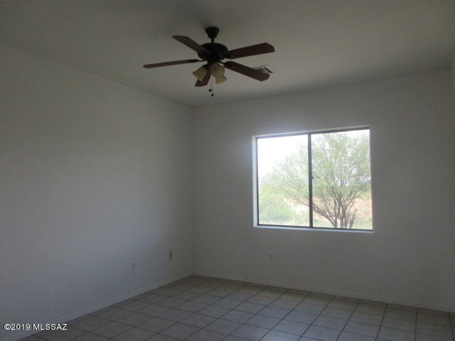965 Circulo Tumbleweed Rio Rico, AZ 85648 - Photo 10 of 18 an empty room with ceiling fan and windows