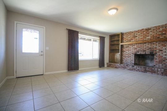 237 South American Street Ridgecrest, CA 93555 - Photo 3 of 26 an empty room with windows and fireplace