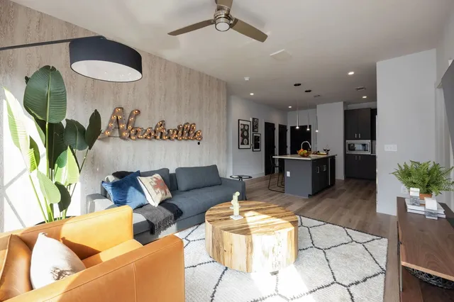 a living room with stainless steel appliances kitchen island granite countertop furniture and a large window