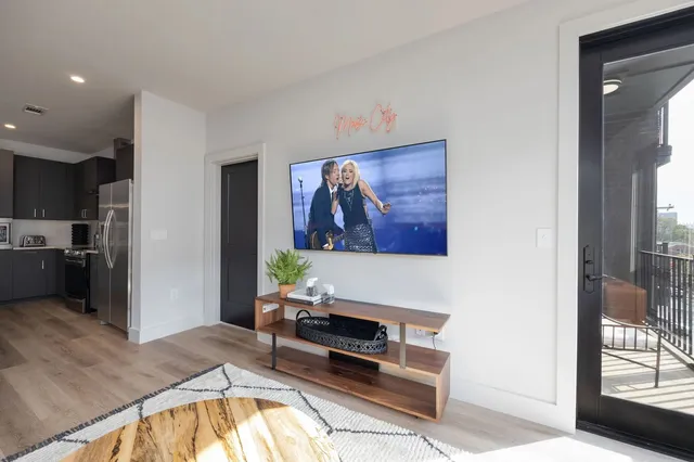 a kitchen with stainless steel appliances granite countertop a sink dishwasher stove and refrigerator with wooden floor