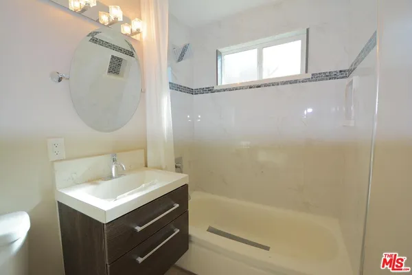 a bathroom with a sink mirror toilet and bathtub