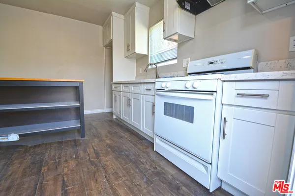 a kitchen with granite countertop white cabinets and white appliances