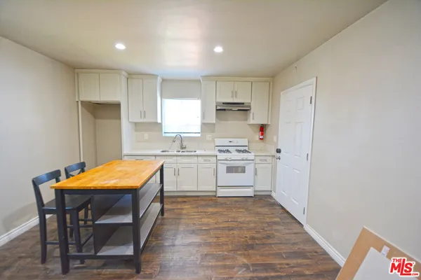 a kitchen with stainless steel appliances granite countertop a white cabinets and wooden floor