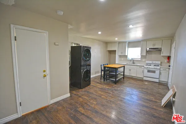 a open kitchen with stainless steel appliances granite countertop a refrigerator stove top oven and sink