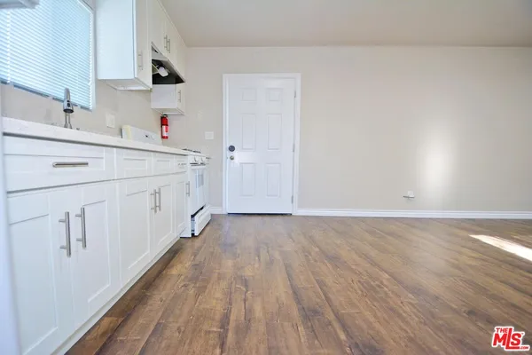 a view of a kitchen with cabinets and wooden floor