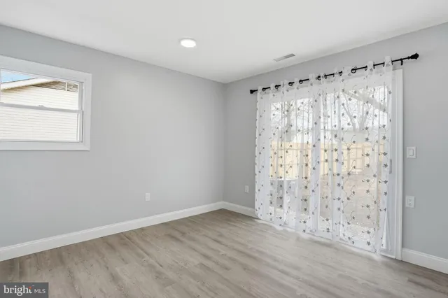 an empty room with wooden floor and a window