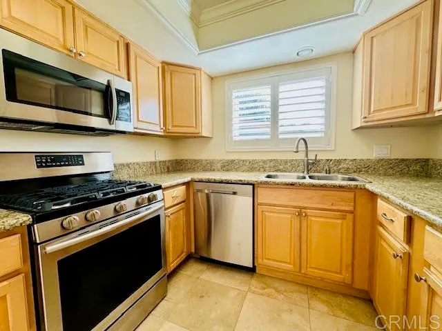 a kitchen with stainless steel appliances granite countertop a stove a sink and a microwave