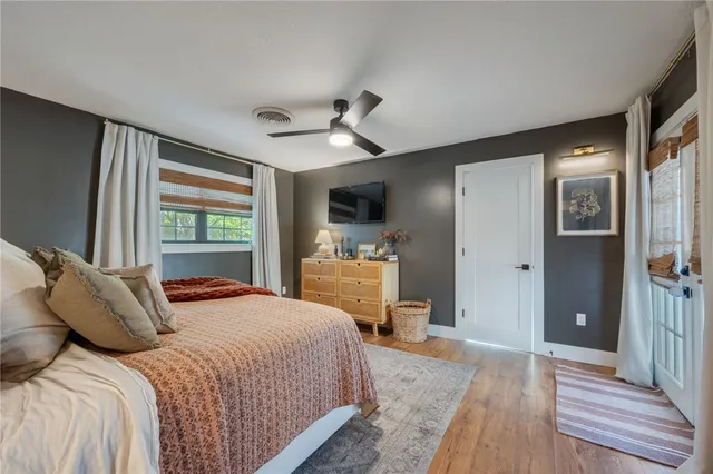 a bedroom with a bed and a flat tv screen on dresser