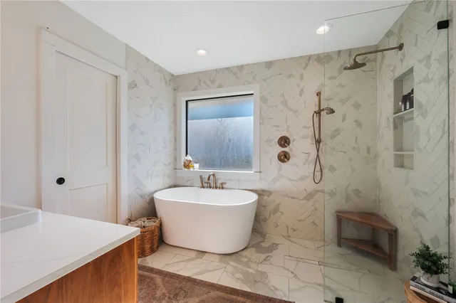 a spacious bathroom with a tub sink and mirror