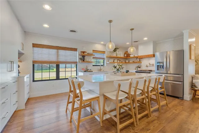 a view of a dining room and kitchen with a table chairs