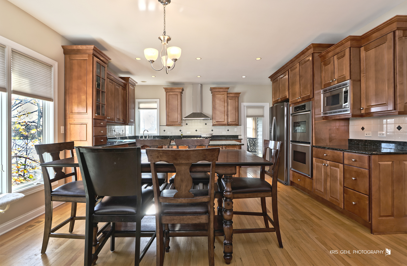 1265 Bayshore Drive Antioch, IL 60002 - Photo 9 of 42 a kitchen with stainless steel appliances granite countertop a dining table chairs refrigerator and cabinets