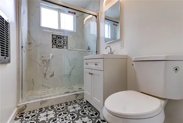 a bathroom with a granite countertop toilet sink and shower