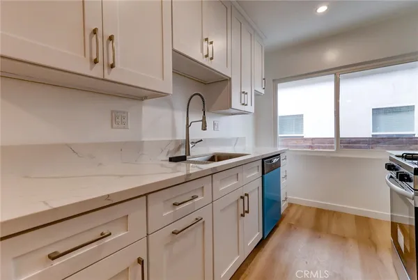 a kitchen with granite countertop white cabinets and a sink