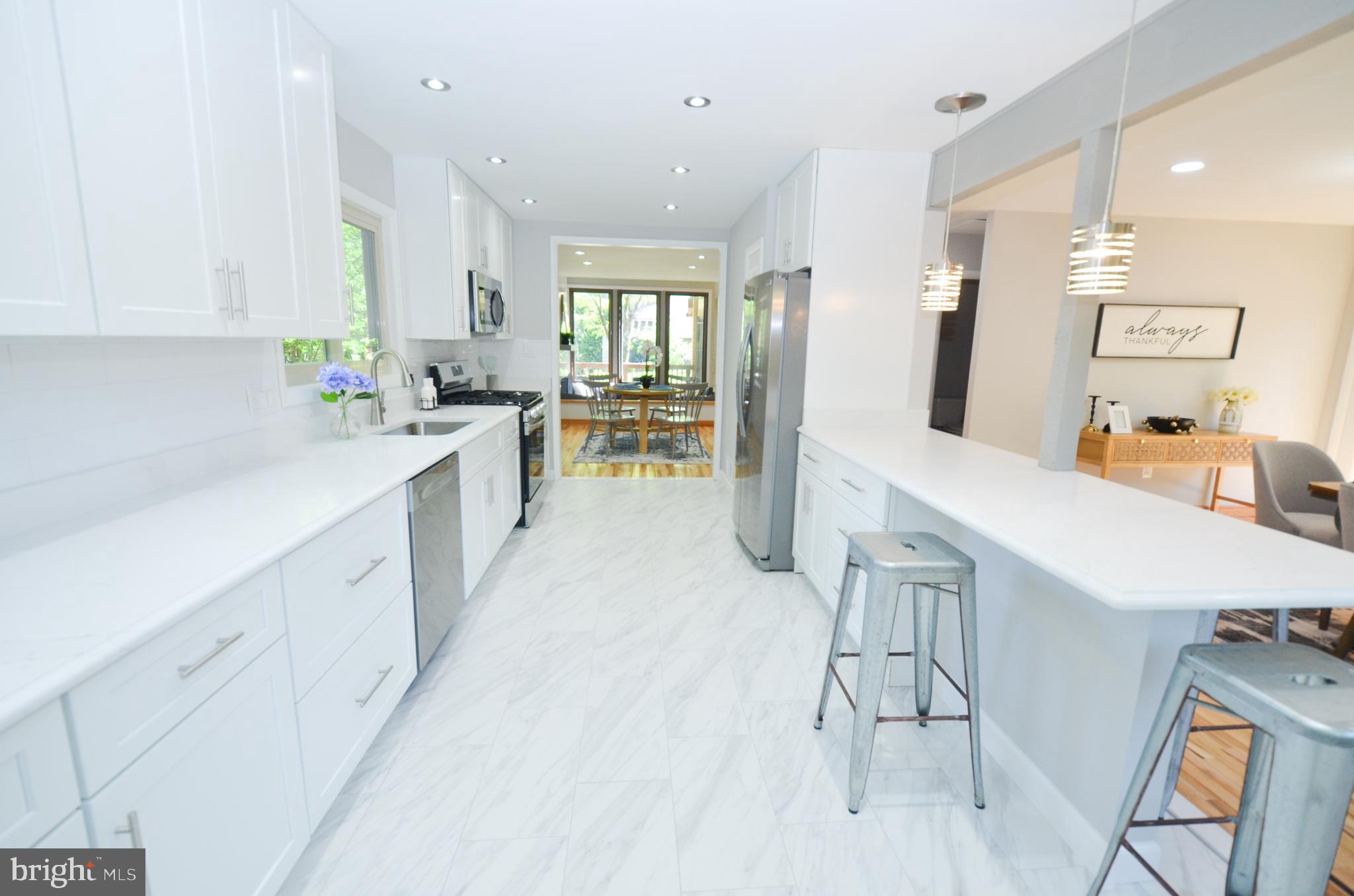 10601 Fiesta Road Fairfax, VA 22032 - Photo 12 of 58 a large white kitchen with a lot of cabinets a sink and a wooden floor