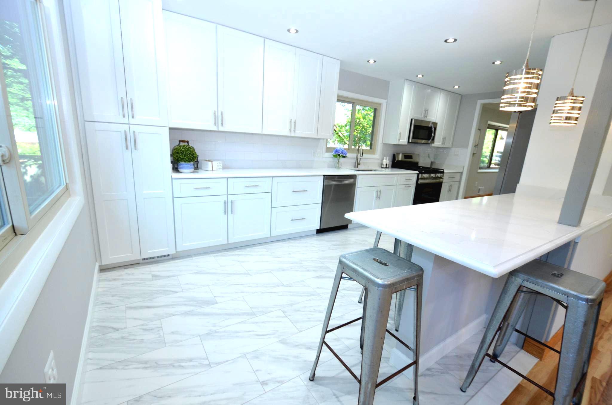 10601 Fiesta Road Fairfax, VA 22032 - Photo 17 of 58 a kitchen with a sink a refrigerator a stove a dining table and chairs