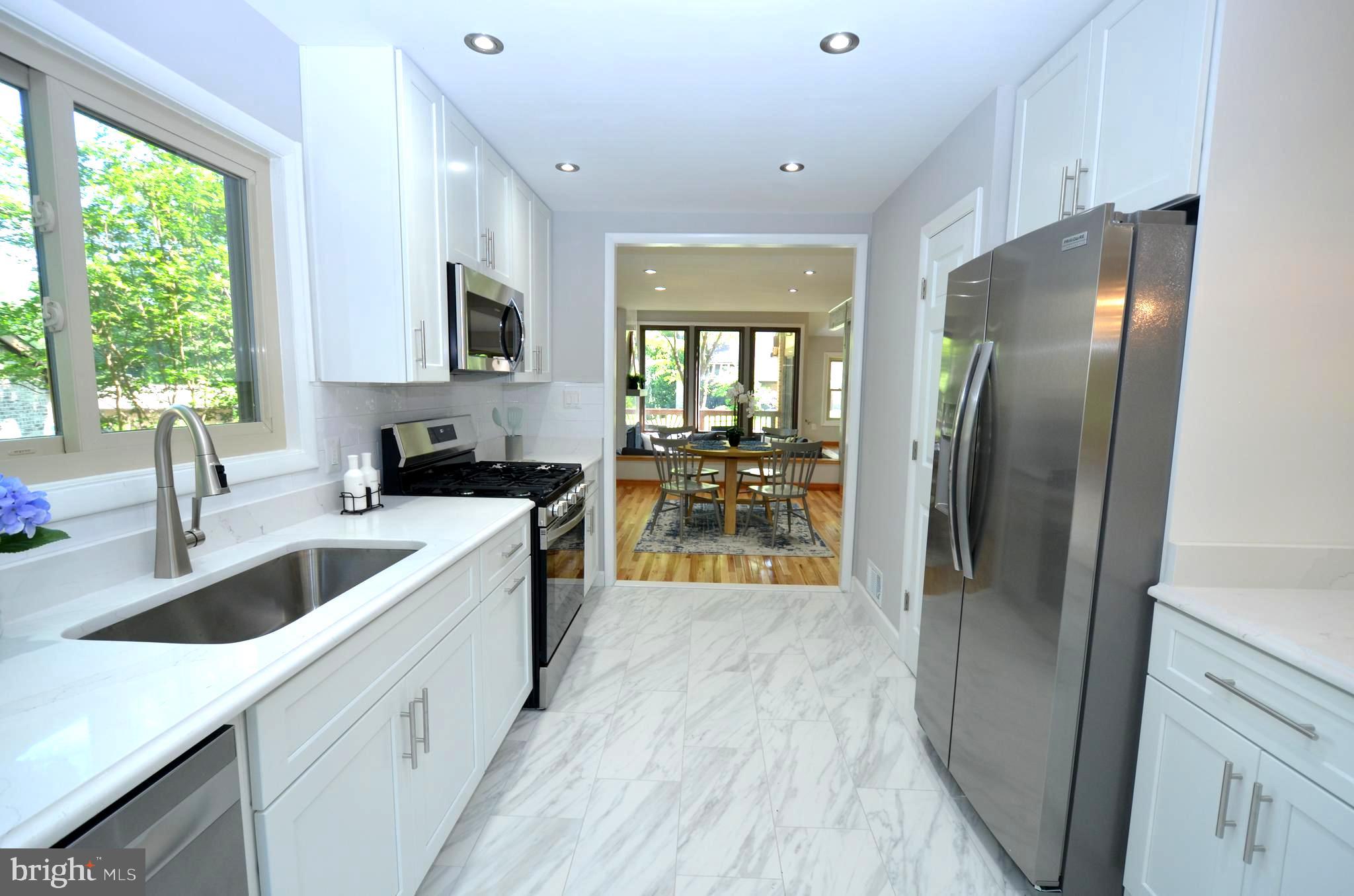 10601 Fiesta Road Fairfax, VA 22032 - Photo 18 of 58 a kitchen with stainless steel appliances granite countertop a refrigerator a sink a stove and a refrigerator with wooden floor
