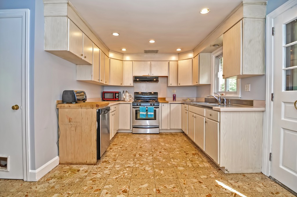 406 Potter Road Framingham, MA 01701 - Photo 9 of 30 a kitchen with white cabinets and appliances