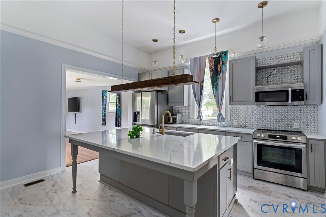 a kitchen with stainless steel appliances granite countertop a sink a stove and a refrigerator