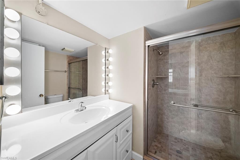 170 Turtle Lake Court, Unit 109 Naples, FL 34105 - Photo 7 of 19 Full bathroom with vanity and a shower stall