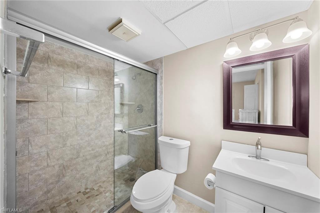 170 Turtle Lake Court, Unit 109 Naples, FL 34105 - Photo 8 of 19 Full bathroom featuring vanity and a shower stall
