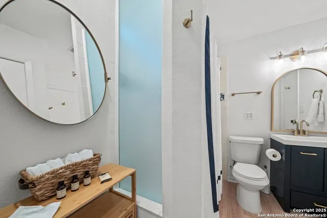 a bathroom with a toilet a sink and mirror