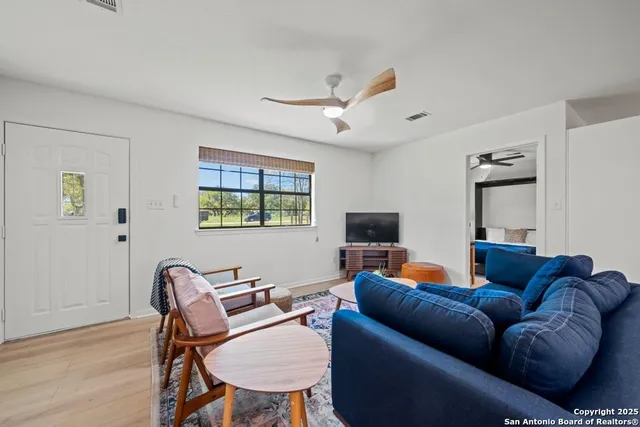 a living room with furniture a ceiling fan and a window