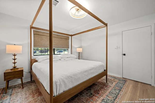 a large bed sitting in a bedroom next to a window