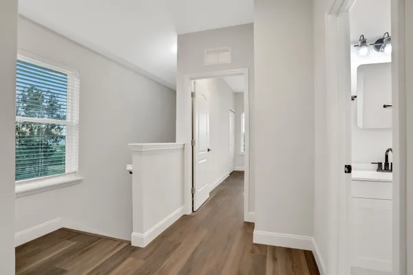 a view of a hallway with wooden floor and closet