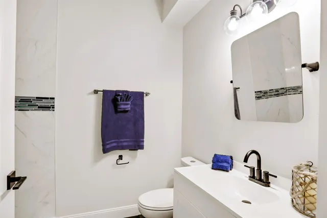 a bathroom with a sink vanity mirror and toilet