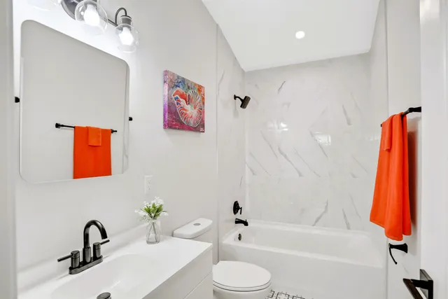 a bathroom with a sink a toilet and tub