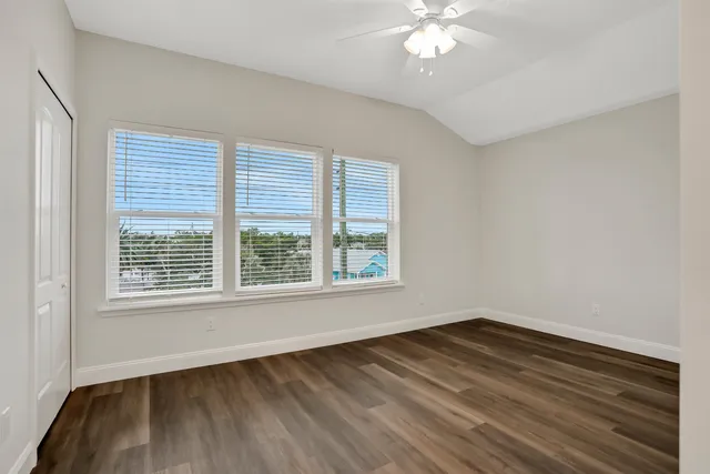 a view of a room with wooden floor and chandelier fan