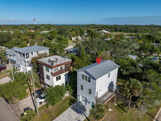 an aerial view of residential houses with outdoor space and trees