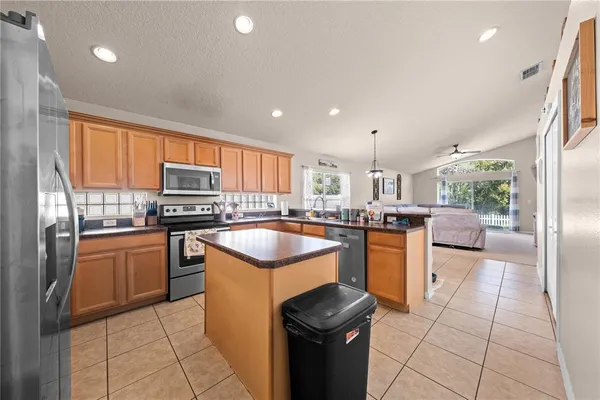 a kitchen with stainless steel appliances granite countertop a stove a sink and a refrigerator