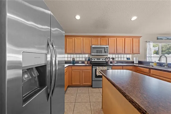 a kitchen with stainless steel appliances a sink stove and refrigerator