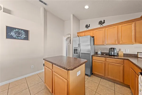 a view of kitchen with granite countertop a couch and a coffee maker next to a window