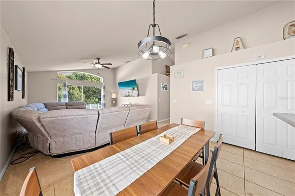 a kitchen with stainless steel appliances kitchen island granite countertop a refrigerator a stove a kitchen island with a dining table and chairs