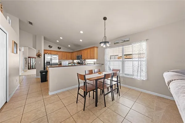 a kitchen with stainless steel appliances granite countertop a refrigerator a sink a stove and a refrigerator